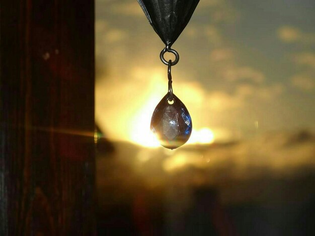 Foto close-up di una palla di cristallo appesa alla finestra al tramonto