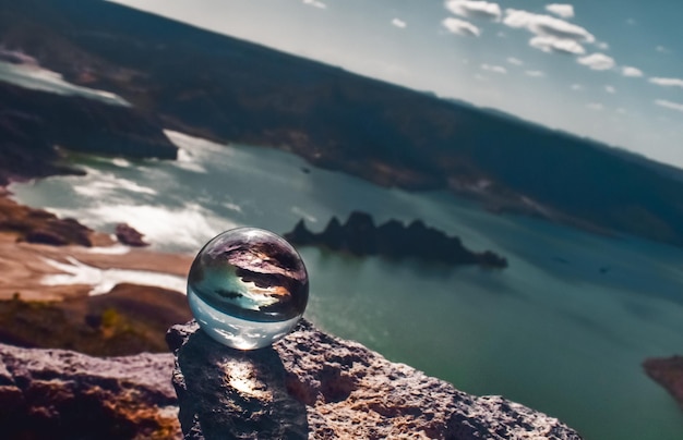 Foto close-up di una palla di cristallo su una roccia contro il mare