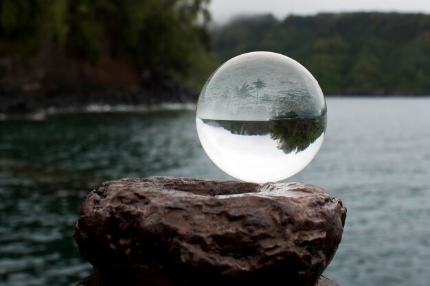 Foto close-up di una palla di cristallo sulla roccia vicino al lago