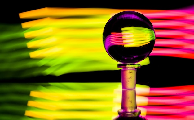 Close-up of crystal ball on table against illuminated lights