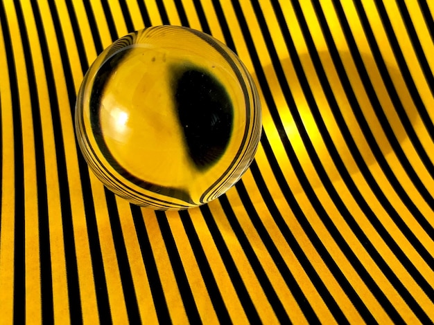 Close-up of crystal ball on yellow and black striped table