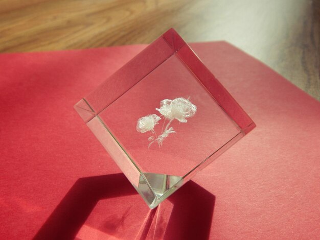 Close-up of cube shape glass on red paper