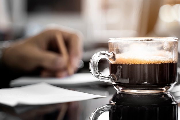 Foto chiuda in su della tazza di caffè sulla tabella con luce solare di mattina