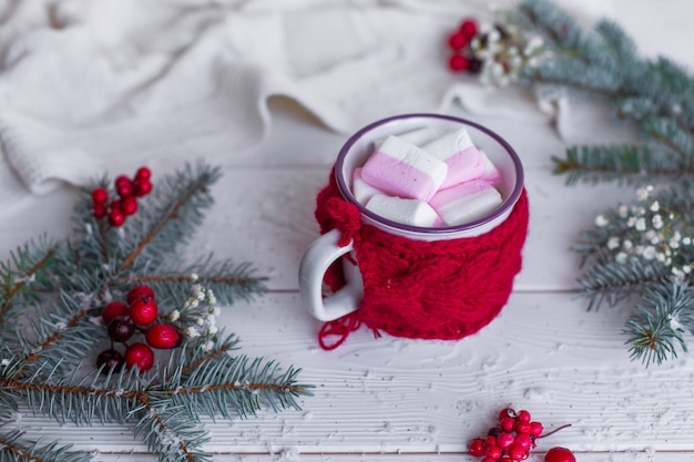 Close up cup of hot chocolate with marshmellows on christmas decorated white wooden table