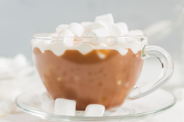 Foto chiuda in su della tazza della bevanda calda deliziosa del cacao con le caramelle gommosa e molle.