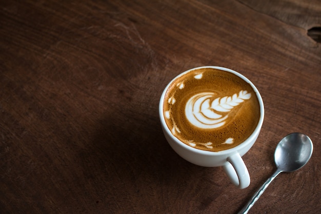 Close up of Cup of hot latte art coffee on wooden table