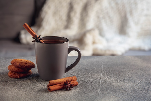 Close up. Cup of tea or coffee with cinnamon and cookies isolated on grey and white background. The concept of home atmosphere and comfort, holidays, romantic date, winter, Christmas or New Year.