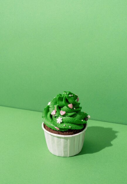 close-up of cupcakes on table against green background