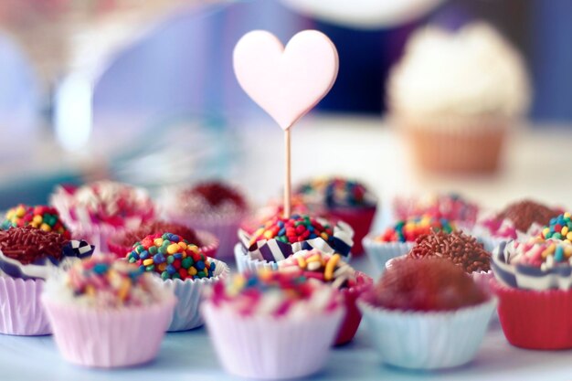 Photo close-up of cupcakes with heart shape on table