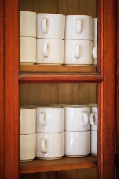 Photo close-up of cups arranged in shelf