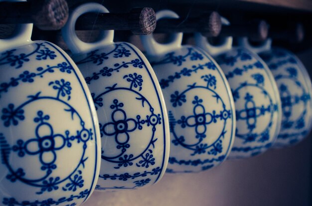 Photo close-up of cups hanging in row at home