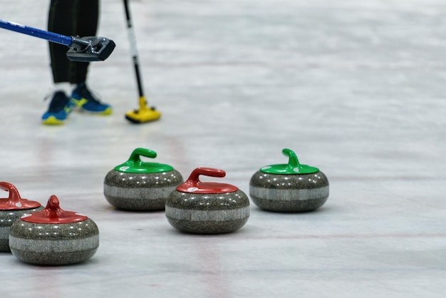 Photo close-up of curling stones on ice rink