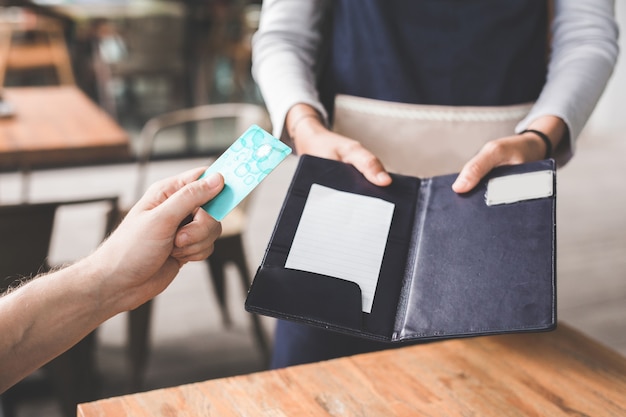 Close up of customer hand paying his bills using credit card