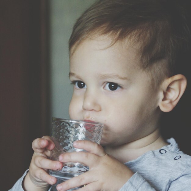 Photo close-up of cute baby boy drinking