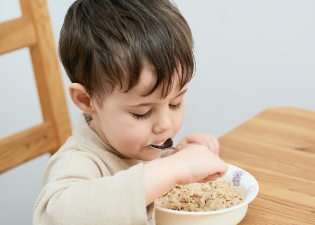 Photo close-up of cute baby boy eating food at home