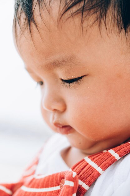 Photo close-up of cute baby boy sitting indoors