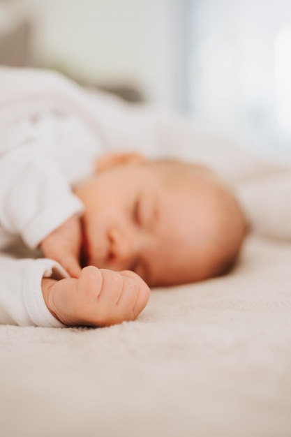 Close-up of cute baby boy sleeping on bed at home