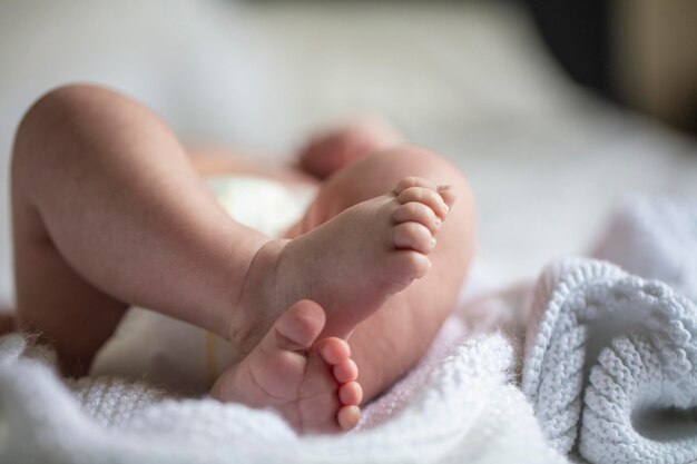 Close up of cute baby feet as they are laying on a bed