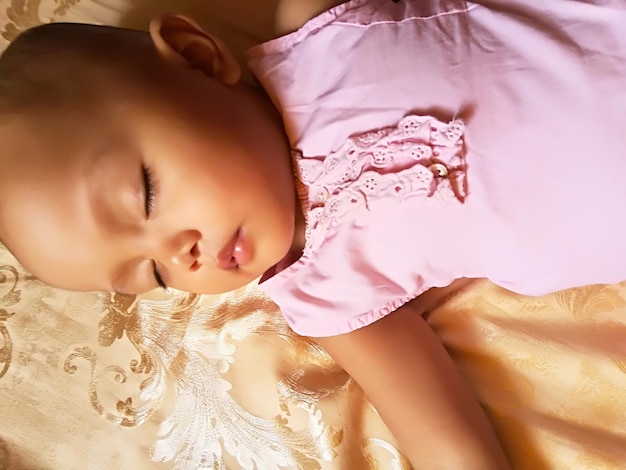Close-up of cute baby girl sleeping on bed at home