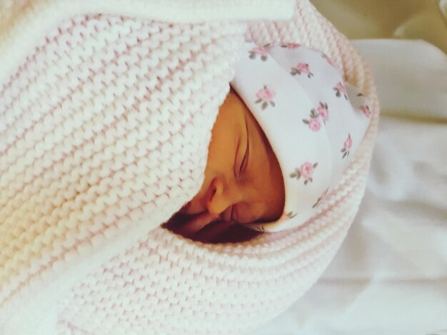 Photo close-up of cute baby girl sleeping on bed at home