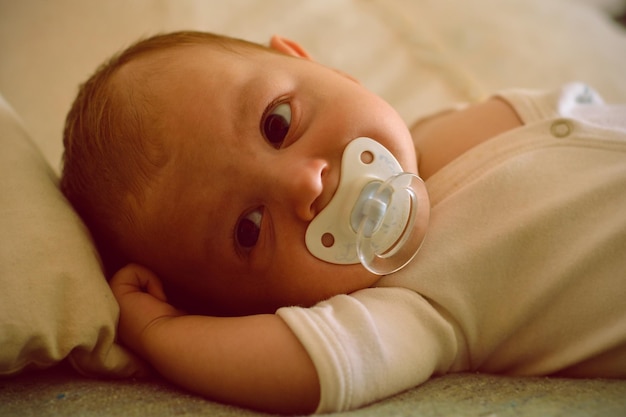 Close-up of cute baby lying on bed at home