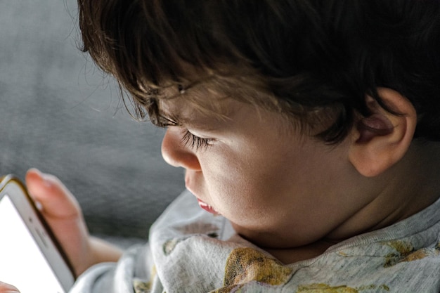 close-up of cute boy using mobile phone