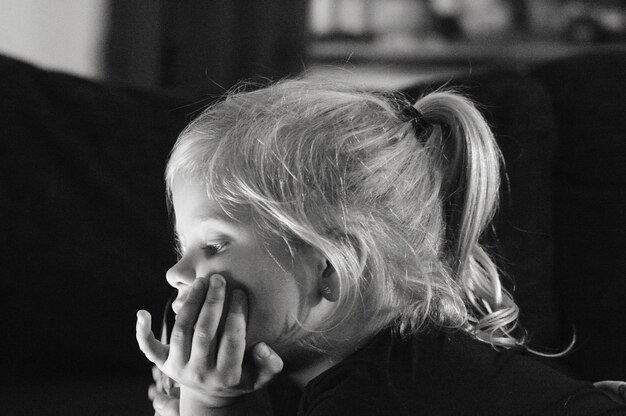 Foto close-up di una ragazza carina che guarda lontano a casa