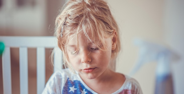 close-up of cute girl with blond messy hair at home