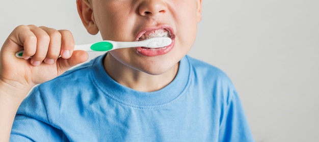 Close-up cute kid brushing his teeth