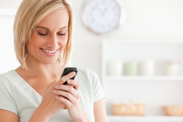 Close up of a cute woman smiling at her mobile