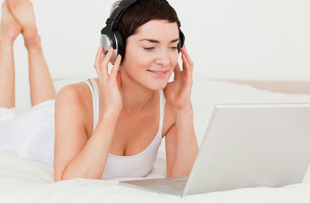 Close up of a cute woman watching a movie with her laptop