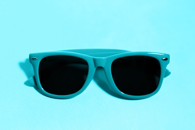 Close-up of cyan sunglasses on aqua menthe color.