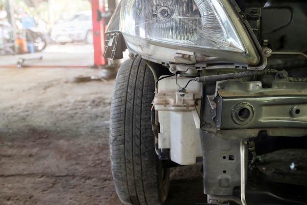 Close up of damaged car waiting to be repaired in the car repair garage.