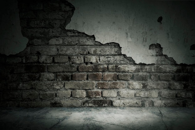 Close up of damaged white plaster on red brick wall of an abandoned house