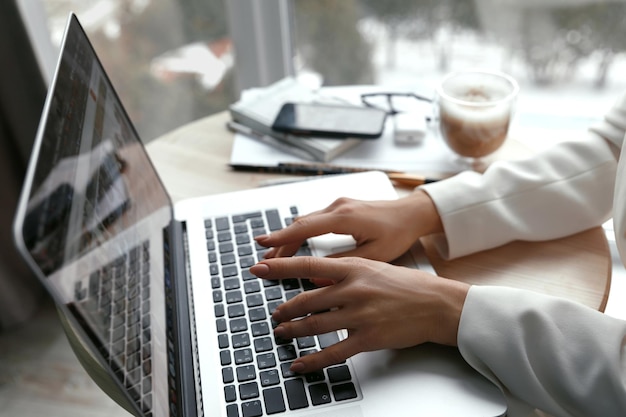 Close-up dames handen met telefoon en werken op laptopcomputer Online shopping concept