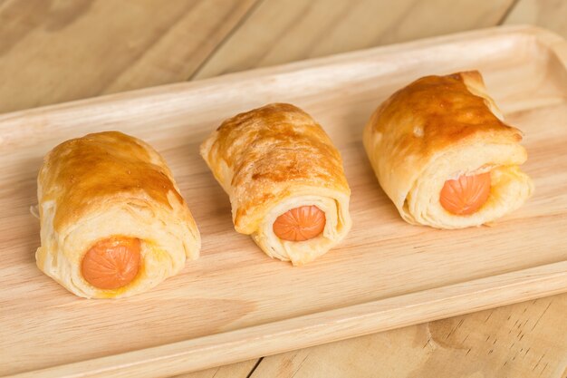 Close up Danish Pastry with sausage on wooden dish