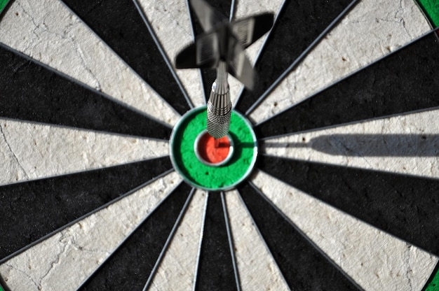 Photo close-up of dart on bulls-eye