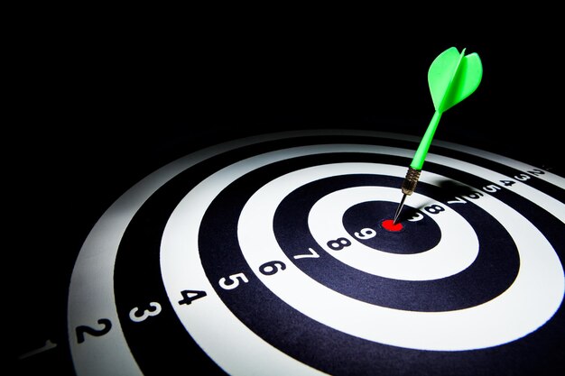 close-up of dart on target over black background