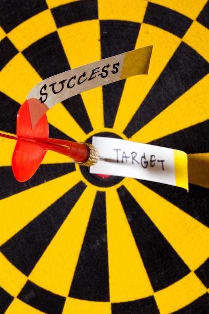 Photo close-up of darts in board with message