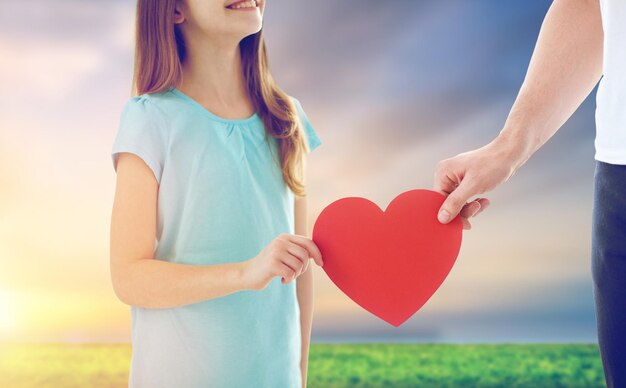 close up of daughter and father holding red heart