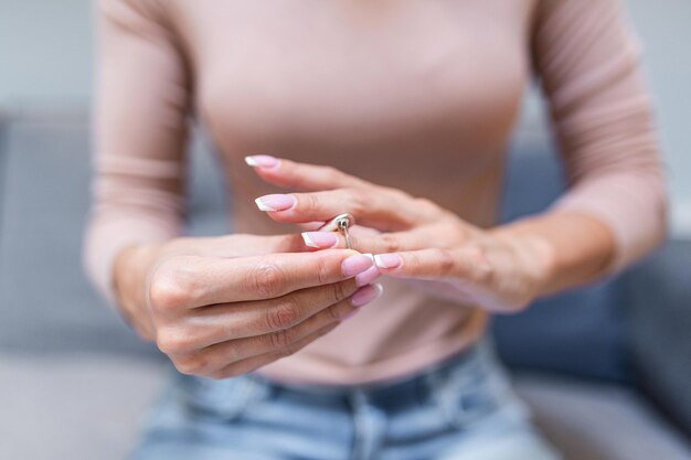 Close up of decisive woman take off wedding ring make decision breaking up with husband young female remove engagement jewelry having relationships problems filing for divorce or annulment