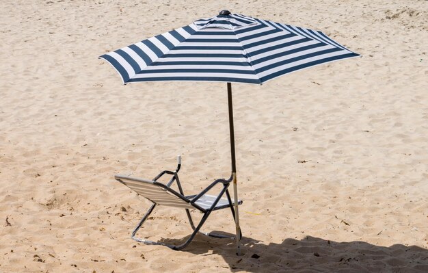 Photo close-up of deck chairs on sand at beach