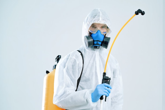 Close-up. decontamination services worker wearing personal protective equipment, spraying disinfectant.