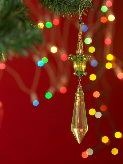 Close-up of decoration hanging from christmas tree against maroon background