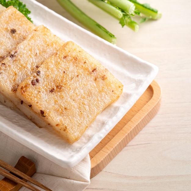 Close up of delicious Chinese radish cake in a plate on wooden table background