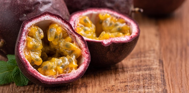 Close up of delicious juicy fresh passion fruit on wooden table background.