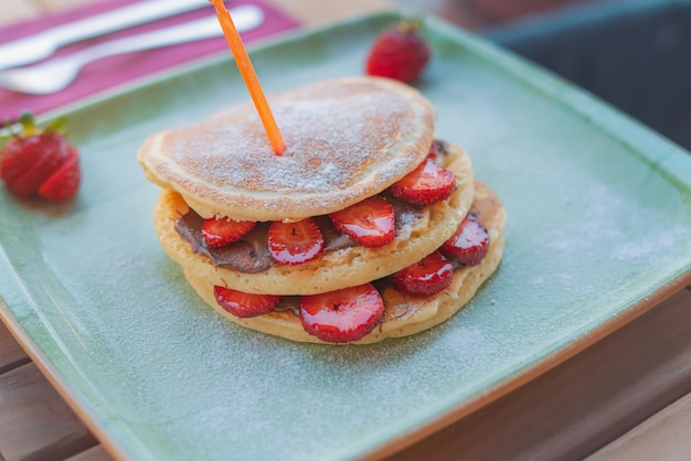 新鮮なイチゴとチョコレート ソースのおいしいパンケーキをクローズ アップ。朝食のコンセプト。