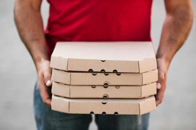 Foto ordine della pizza della tenuta del tipo di consegna del primo piano