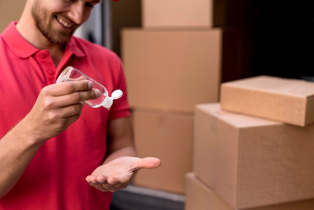 close-up delivery male using hand sanitizer