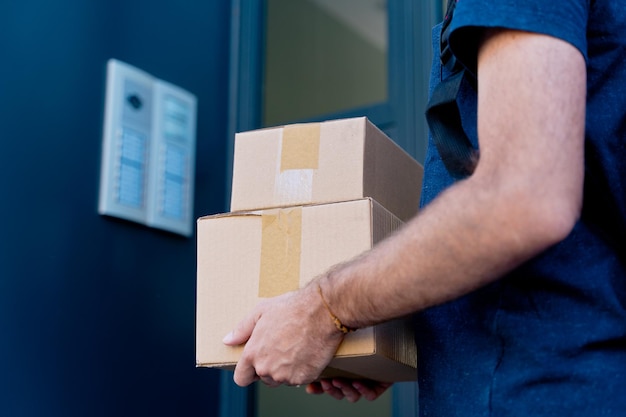 Close up of delivery man delivering parcel box. Courier service concept. horizontal view of unrecognizable rider delivering home a package.